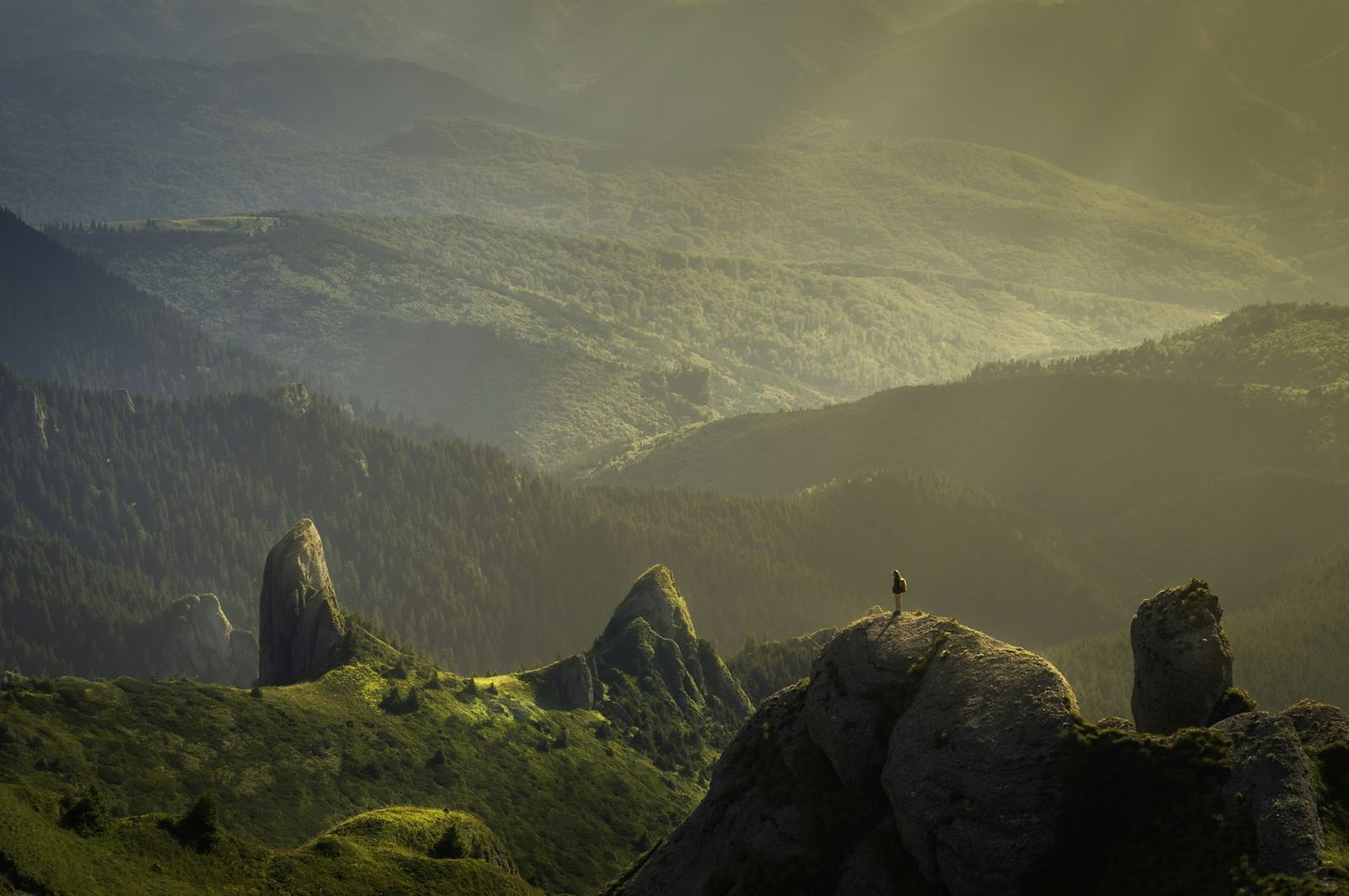 Moody green highlands with a lone hiker