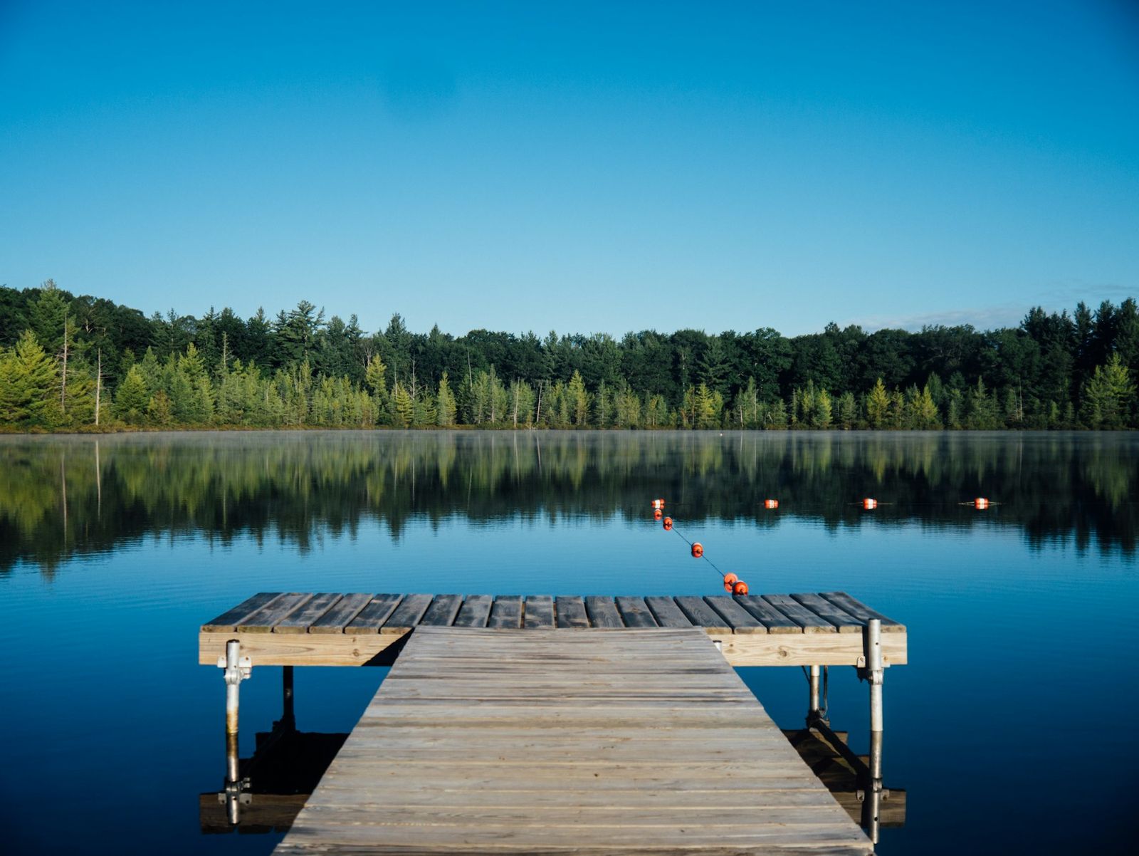 Wooden dock on a mirror-still lake