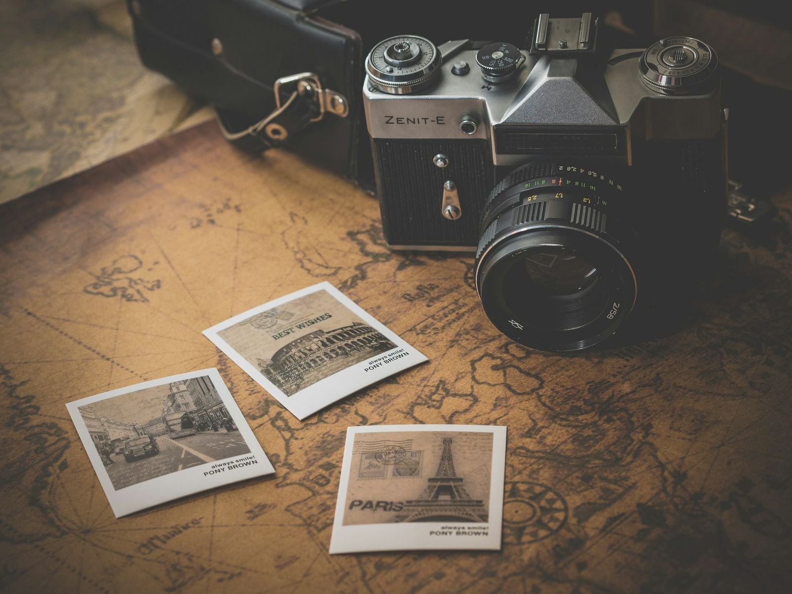 Vintage film camera with instant prints on a map